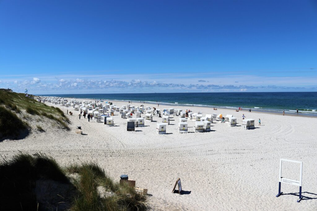 Sandstrand mit Strandkörben und klarem blauen Himmel.